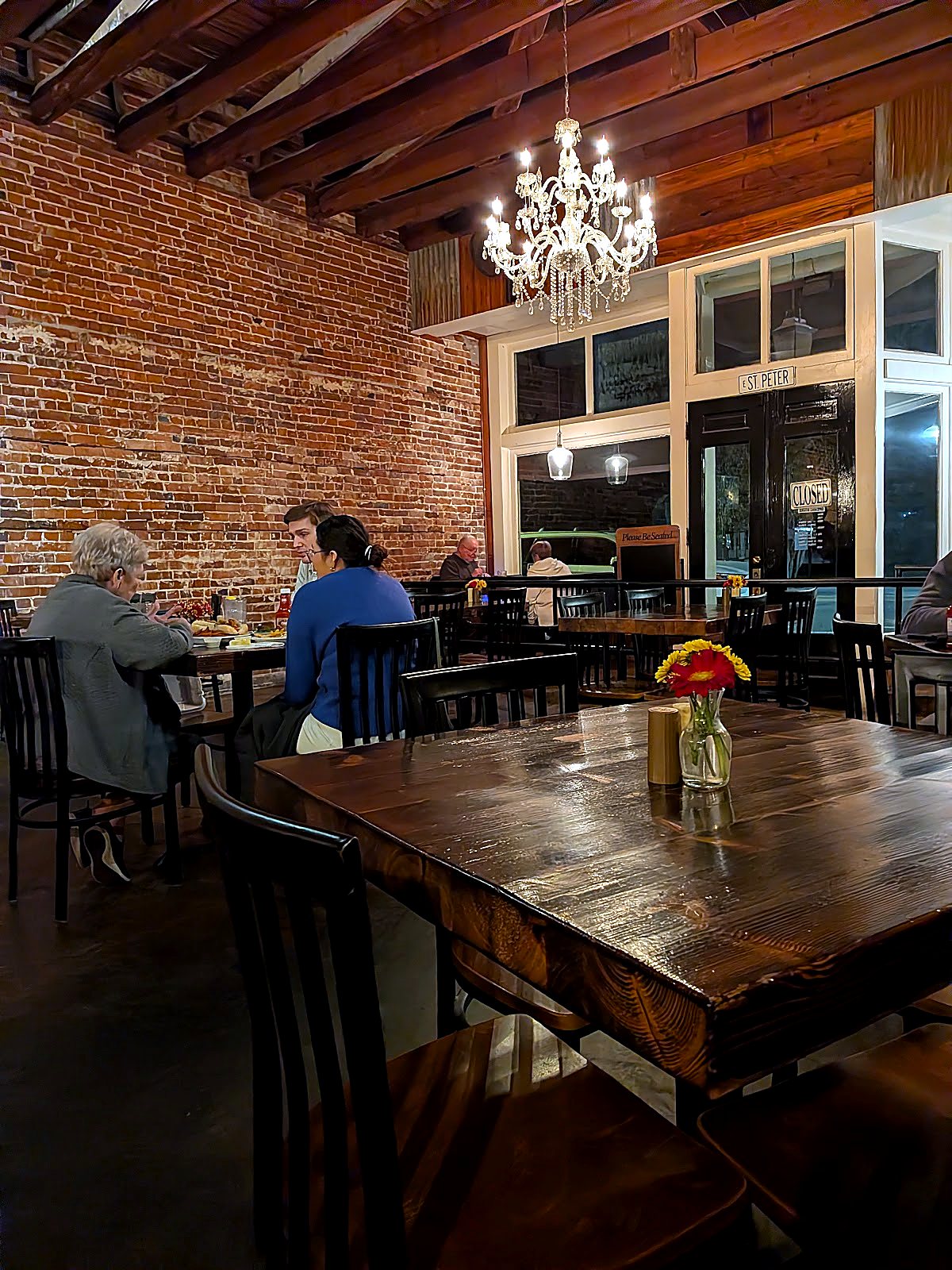 The dining room at Barry's 1965, brick wall and chandelier